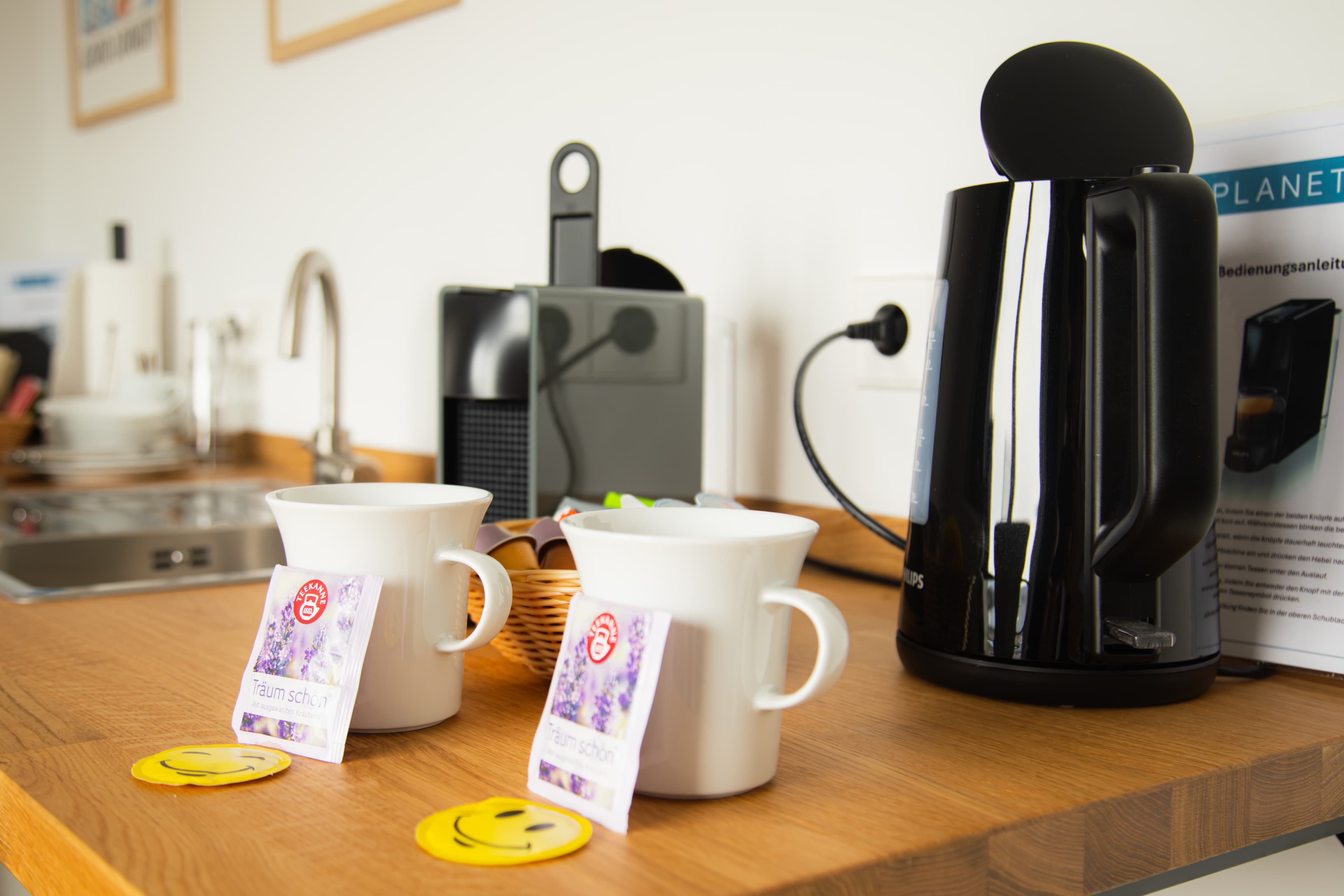 Zwei Tassen mit Lavendel-Teebeuteln vor Nespresso-Maschine und Wasserkocher